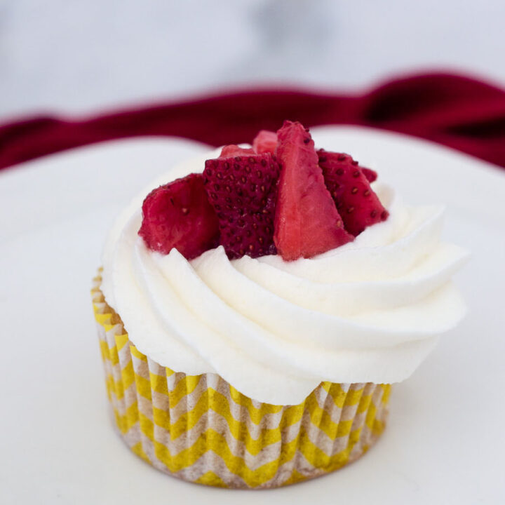 Strawberry shortcake cupcakes are an easy dessert that kids and adults alike will enjoy. Vanilla cupcakes are topped with whipped cream and strawberries.