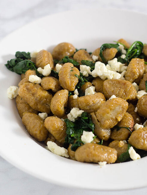 Pumpkin gnocchi and spinach with sage brown butter sauce is a hearty vegetarian meal full of flavor. You won't miss the meat! #SundaySupper