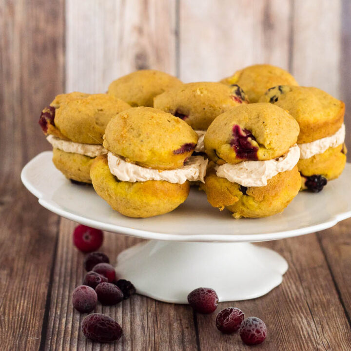 Two soft, light pumpkin cookies studded with fresh cranberries are sandwiched with creamy dulce de leche marshmallow filling.