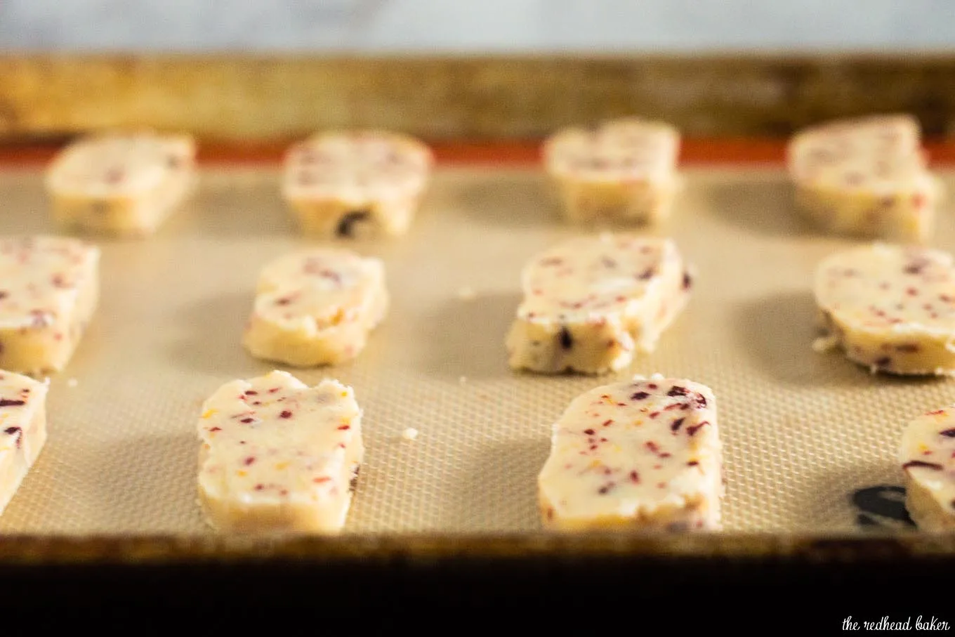 Shortbread cookies are a Scottish Christmas tradition. This version of the crumbly cookie is flavored with dried cranberries and orange zest. #IntnlCookies