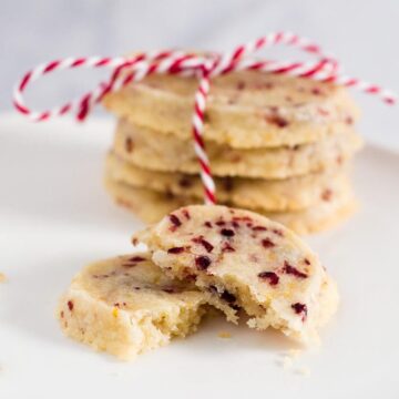 Shortbread cookies are a Scottish Christmas tradition. This version of the crumbly cookie is flavored with dried cranberries and orange zest. #IntnlCookies