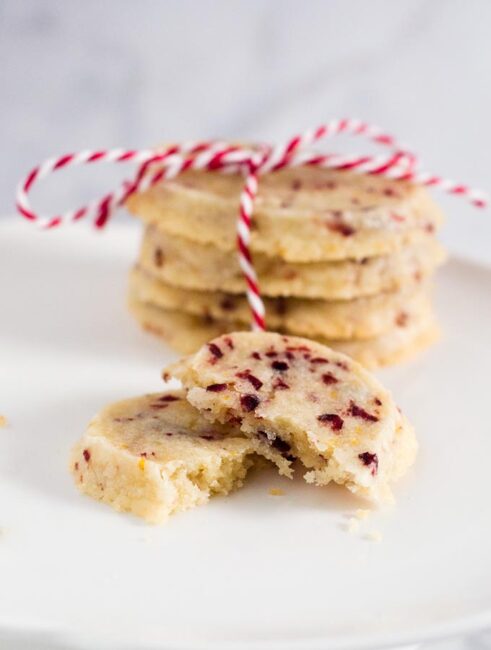 Shortbread cookies are a Scottish Christmas tradition. This version of the crumbly cookie is flavored with dried cranberries and orange zest. #IntnlCookies