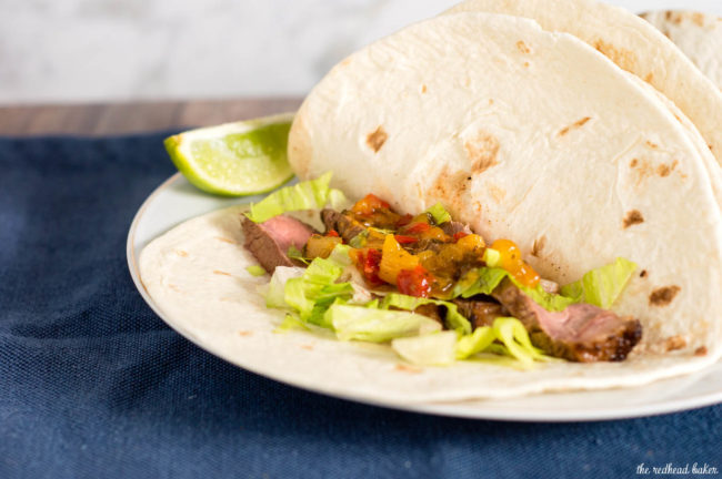 Flank steak tacos use a lean cut of beef, tenderized with a chile-lime marinade, as taco filling in soft tortillas, topped with shredded lettuce and pineapple salsa. #SundaySupper
