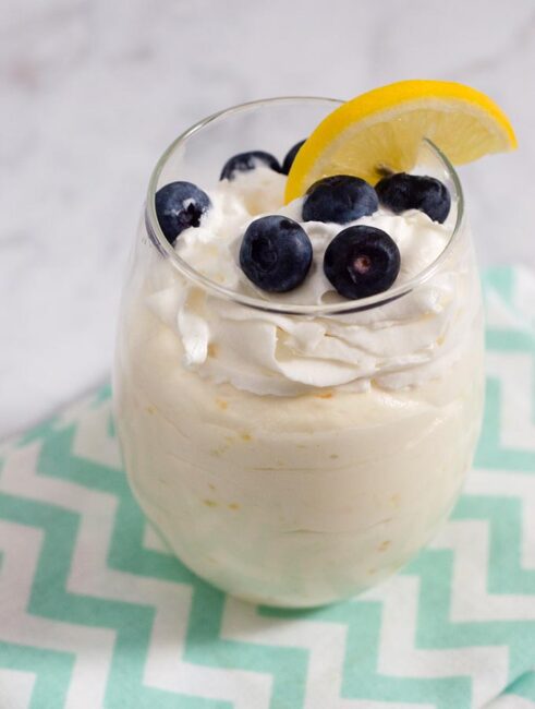 Meyer lemon mousse topped with fresh berries combines the curd of tangy-sweet meyer lemons with whipped cream for a flavorful, light dessert. #ProgressiveEats