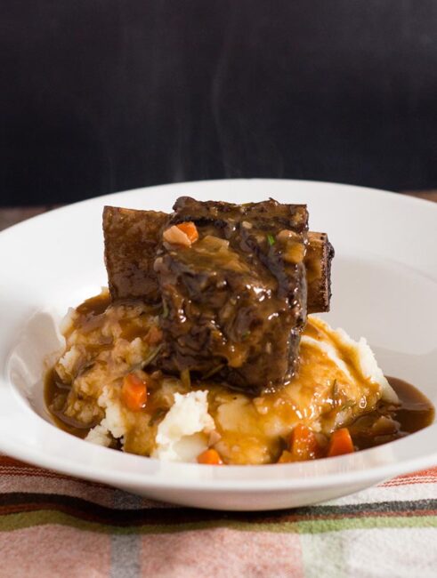 Beef short ribs become fall-off-the-bone tender in a braise of red wine, beef stock, and garlic. Serve over mashed potatoes for a true comfort meal.