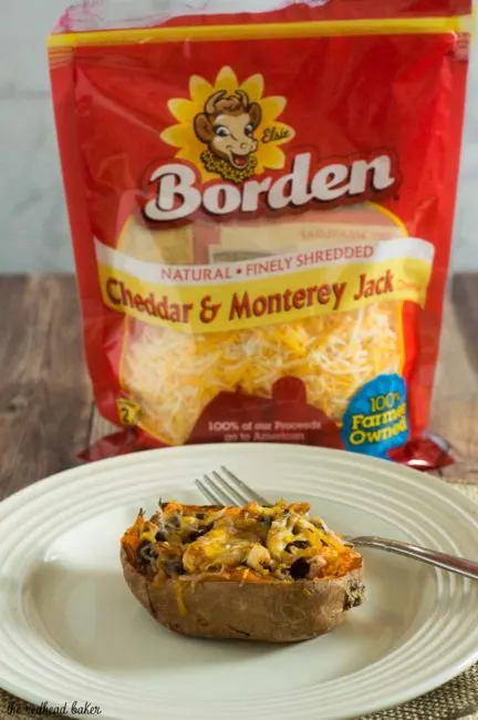 Twice-baked sweet potatoes are stuffed with a mixture of mashed sweet potatoes, black beans, onion, garlic and spices, and topped with melty Borden&reg; Cheese for a healthier vegetarian dinner. #BordenCheeseLove #Ad
