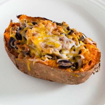 Twice-baked sweet potatoes are stuffed with a mixture of mashed sweet potatoes, black beans, onion, garlic and spices, and topped with melty Borden® Cheese for a healthier vegetarian dinner. #BordenCheeseLove #Ad