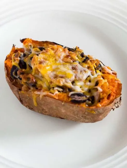 Twice-baked sweet potatoes are stuffed with a mixture of mashed sweet potatoes, black beans, onion, garlic and spices, and topped with melty Borden&reg; Cheese for a healthier vegetarian dinner. #BordenCheeseLove #Ad