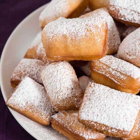 Mardi Gras means it's time for beignets! This is a classic New Orleans recipe, deep-fried then coated in powdered sugar, and served with raspberry jam.