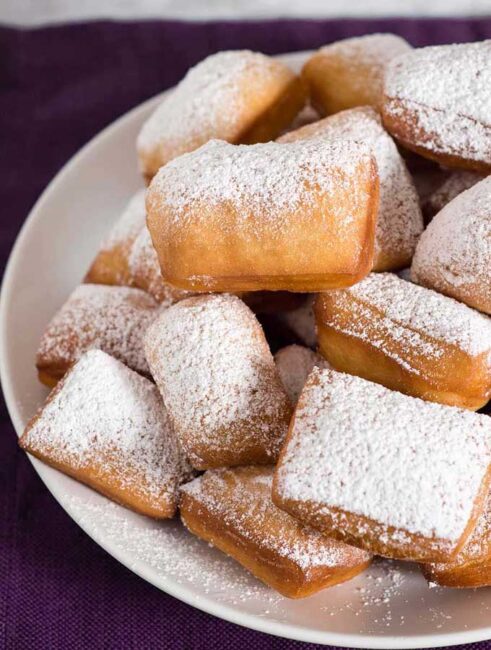 Mardi Gras means it's time for beignets! This is a classic New Orleans recipe, deep-fried then coated in powdered sugar, and served with raspberry jam.