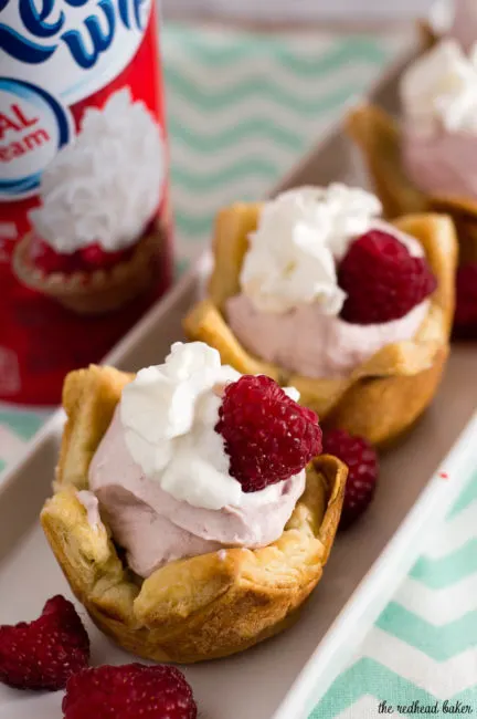 Mini raspberry mousse tartlets are full of spring flavor! Raspberry curd gives them a spring pink tint, and they are finished with a dollop of Reddi-wip&reg;! #SpringReddi #ad