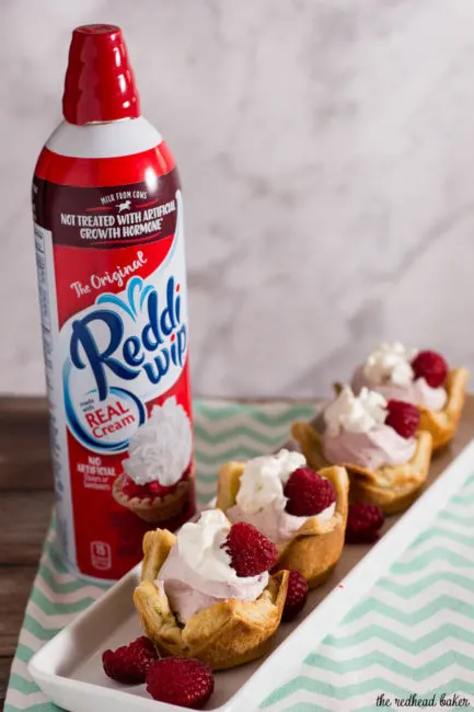 Mini raspberry mousse tartlets are full of spring flavor! Raspberry curd gives them a spring pink tint, and they are finished with a dollop of Reddi-wip&reg;! #SpringReddi #ad
