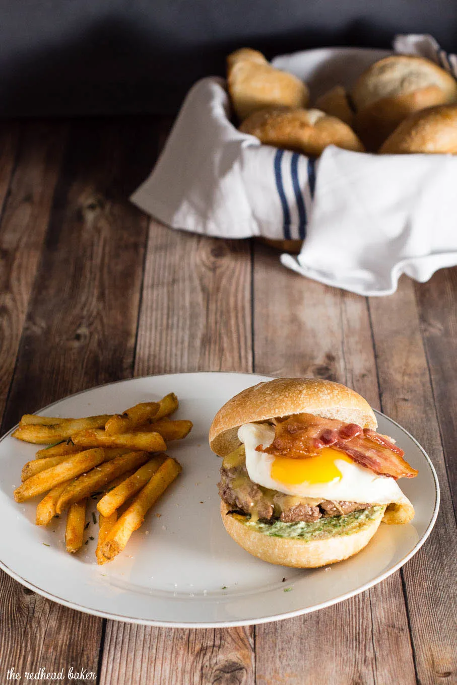 These French Bistro Burgers are full of over-the-top flavor: an herb aioli, smoked gouda cheese, bacon and a sunnyside up egg. Serve with rosemary fries or a frisee salad. #BurgerMonth #GirlCarnivore