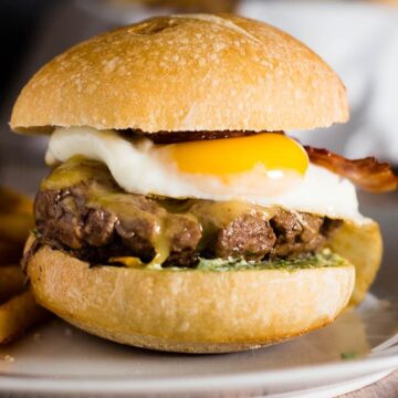 These French Bistro Burgers are full of over-the-top flavor: an herb aioli, smoked gouda cheese, bacon and a sunnyside up egg. Serve with rosemary fries or a frisee salad. #BurgerMonth #GirlCarnivore