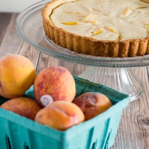 This peach custard tart has a crumbly cookie crust and a creamy custard filling loaded with tender peach slices. It's a delicious end to any meal! #BrunchWeek