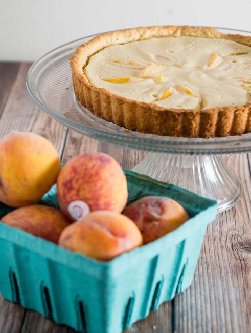 This peach custard tart has a crumbly cookie crust and a creamy custard filling loaded with tender peach slices. It's a delicious end to any meal! #BrunchWeek