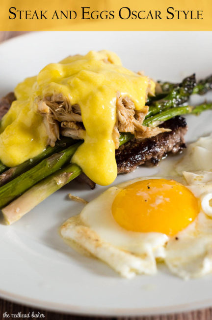 The classic brunch staple of steak and eggs gets fancy! The steak is served Oscar-style with asparagus, crab meat and Hollandaise sauce, with two sunny side-up eggs. #BrunchWeek