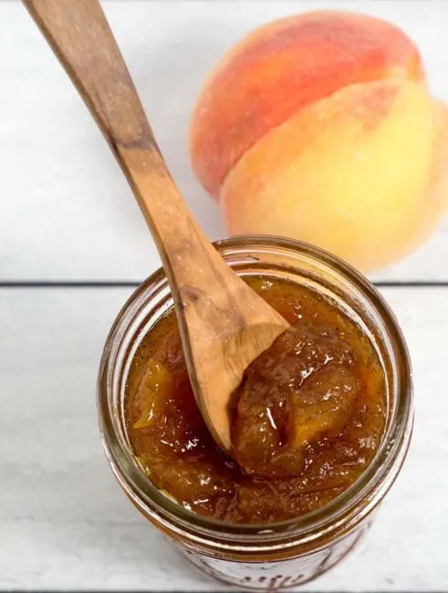 Peach vanilla jam sweetened with honey is canned using the waterbath method (no pectin needed!), so you can have a taste of summer all year long!&nbsp;
