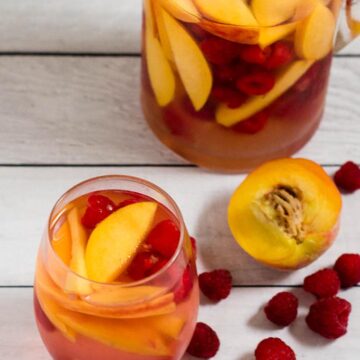 Fresh, sweet summer fruit balances dry white wine in this raspberry peach sangria. It's the perfect summer cocktail for any summer occasion.