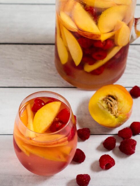 Fresh, sweet summer fruit balances dry white wine in this raspberry peach sangria. It's the perfect summer cocktail for any summer occasion.