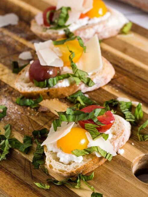 Bruschetta with marinated tomatoes and ricotta is an easy appetizer that epitomizes summer. Using multicolored cherry tomatoes adds visual interest. 