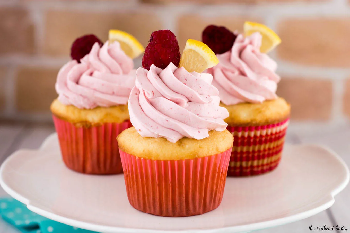 Raspberry lemon cupcakes are a delicious summer dessert. These fluffy cupcakes are filled with tart lemon curd and topped with silky buttercream flavored with raspberry puree. #FarmersMarketWeek