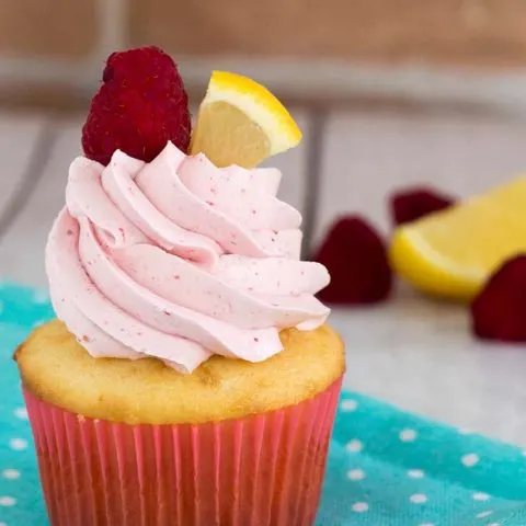 Raspberry lemon cupcakes are a delicious summer dessert. These fluffy cupcakes are filled with tart lemon curd and topped with silky buttercream flavored with raspberry puree. #FarmersMarketWeek