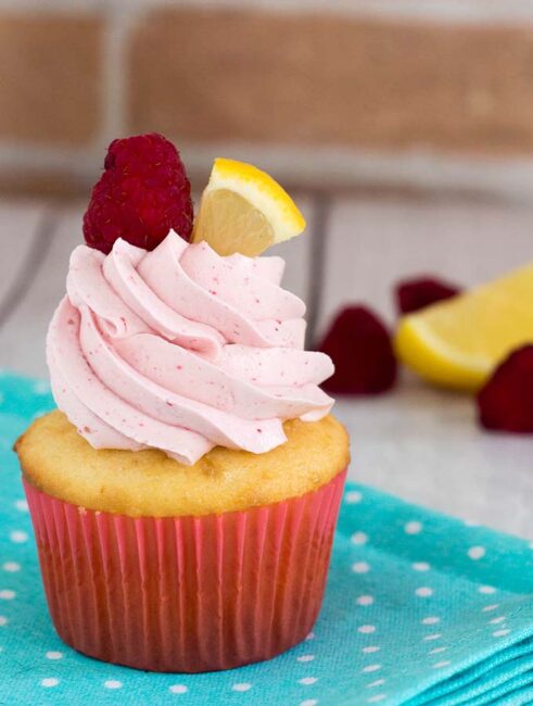 Raspberry lemon cupcakes are a delicious summer dessert. These fluffy cupcakes are filled with tart lemon curd and topped with silky buttercream flavored with raspberry puree. #FarmersMarketWeek