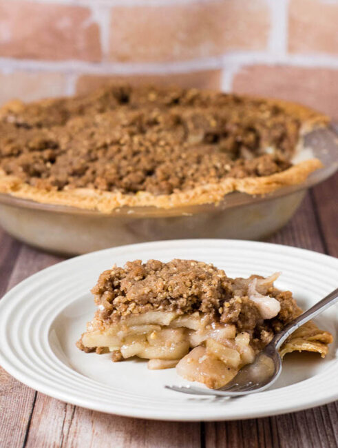 Classic apple pie gets a twist with a cinnamon-spiced oat crumb topping that adds texture and flavor. It's the perfect dessert for any fall occasion! #AppleWeek