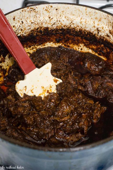 Authentic barbacoa beef tacos are piled with shredded beef cooked low and slow in chili-pepper spiced sauce, and topped with cilantro, salsa and lime wedges.