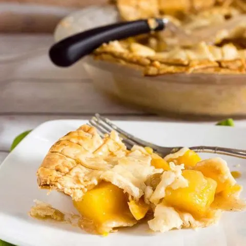 One slice of this mango peach pie is a tropical treat! Chunks of fresh fruit are lightly spiced with cinnamon, ginger and nutmeg. #OXOGoodCookies #BakeADifference