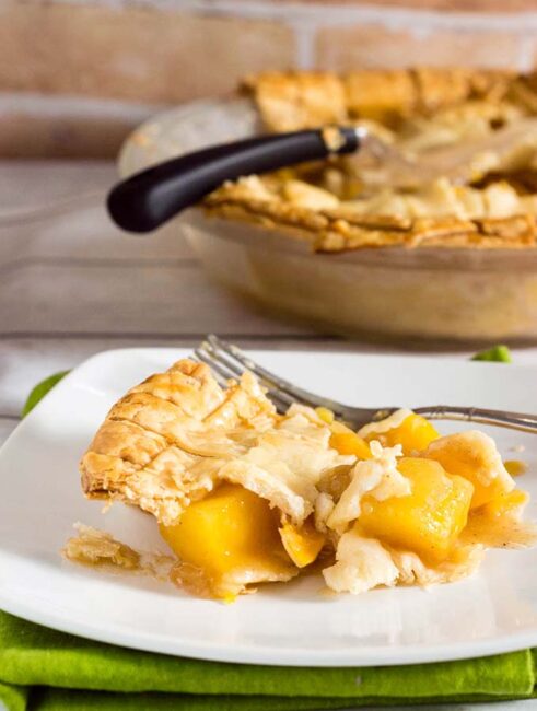 One slice of this mango peach pie is a tropical treat! Chunks of fresh fruit are lightly spiced with cinnamon, ginger and nutmeg.  #OXOGoodCookies #BakeADifference