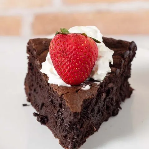 Naturally gluten-free flourless chocolate cake is rich, dense, and has intense chocolate flavor. Top with whipped cream, ice cream or fruit sauce. #Choctoberfest