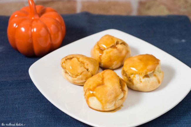 Pumpkin cream puffs are filled with creamy pumpkin custard and dunked in caramel glaze. You've never had a pumpkin dessert like this before! #PumpkinWeek