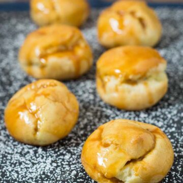 Pumpkin cream puffs are filled with creamy pumpkin custard and dunked in caramel glaze. You've never had a pumpkin dessert like this before! #PumpkinWeek