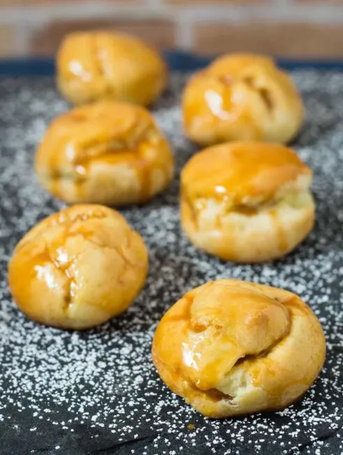 Pumpkin cream puffs are filled with creamy pumpkin custard and dunked in caramel glaze.&nbsp;You've never had a pumpkin dessert like this before!&nbsp;#PumpkinWeek