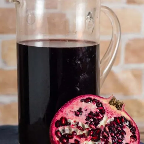 Spiced pomegranate red wine punch is a delicious cocktail for holidays and average days alike. Serve it warm or cold, garnished with a twist of orange rind. 