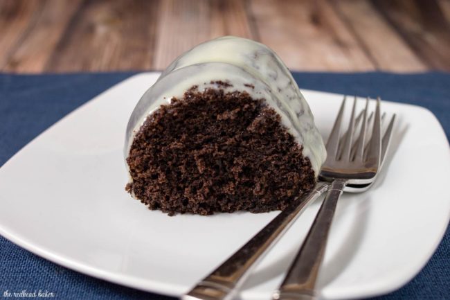 A slice of fudgy chocolate bundt cake on a white plate.