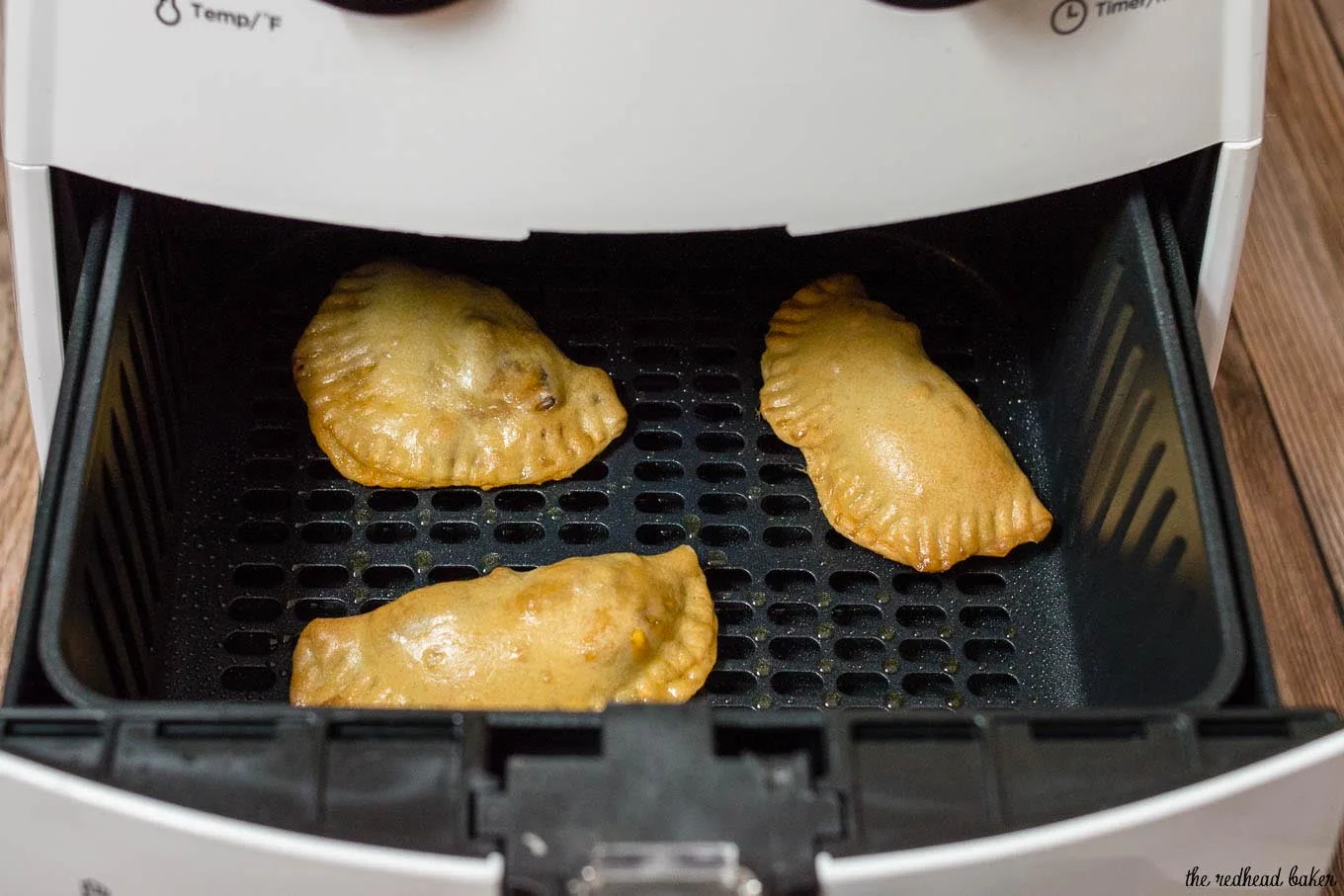Cooked Philly cheesesteak empanadas in the basket of the air frye.r