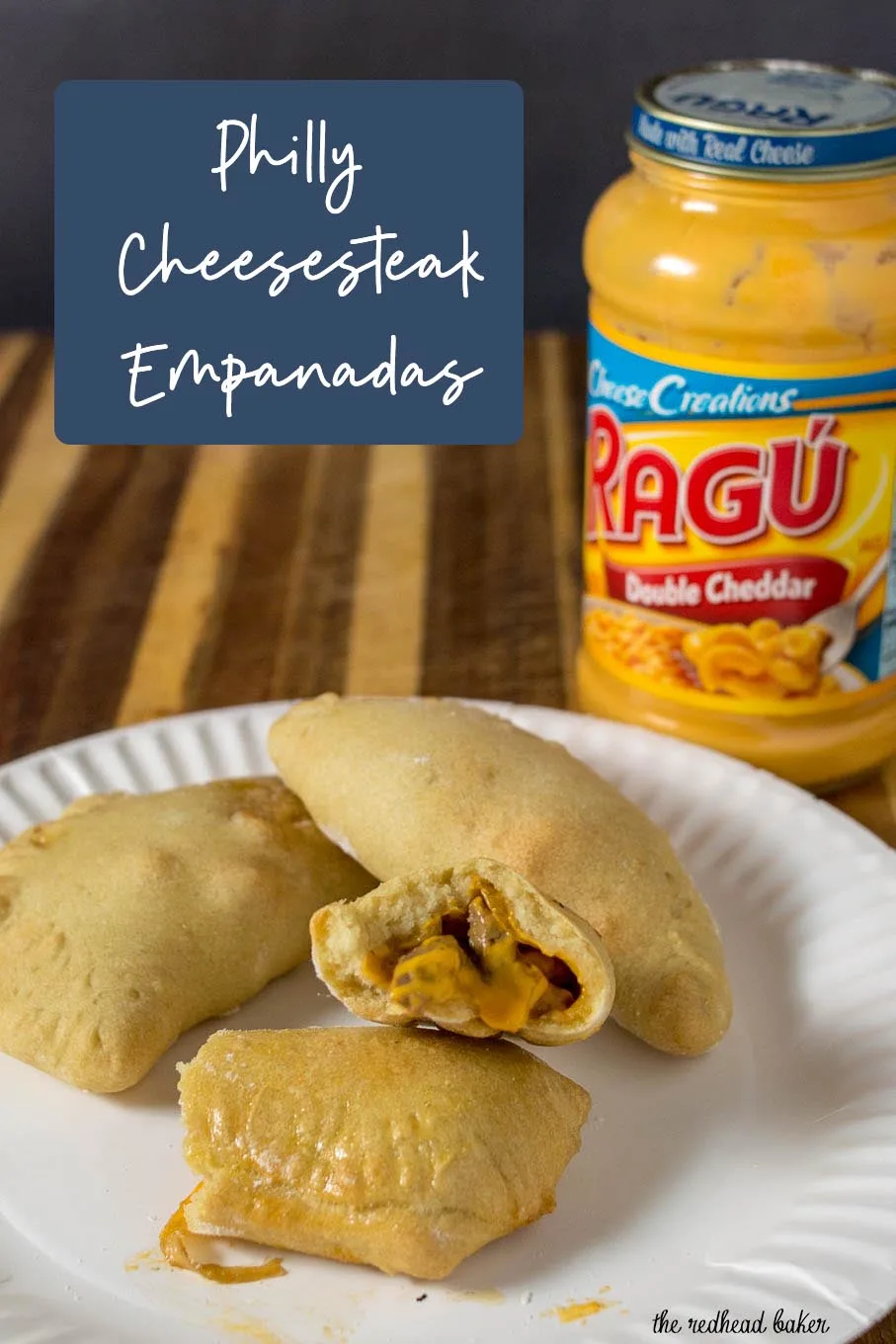 A plate of Philly cheesesteak empanadas with a jar of Ragu Double Cheddar Sauce.