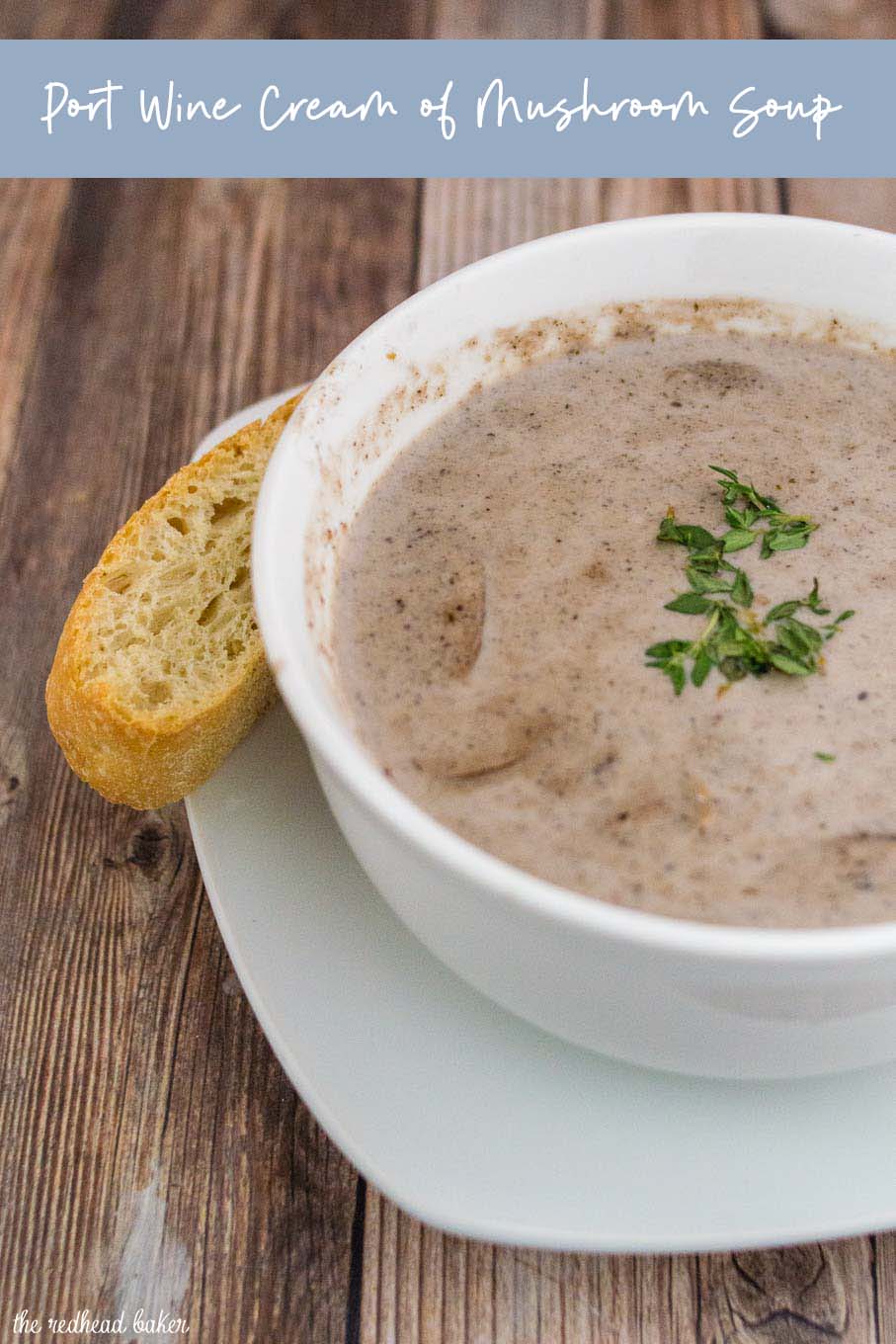 A bowl of port wine cream of mushroom soup with a stick of ciabatta bread on the side