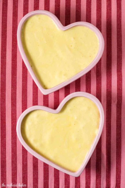 Two ramekins of white chocolate frozen mousse on a pink striped placemat.