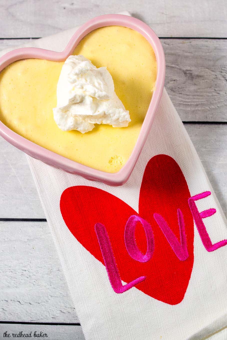 A ramekin of white chocolate frozen mousse on a white tea towel with the word "LOVE" embroidered on it.