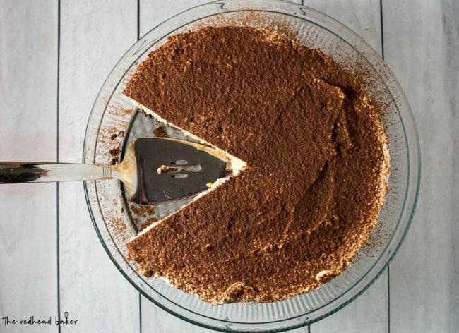 An overhead shot of a tiramisu cheesecake with two slices taken out.