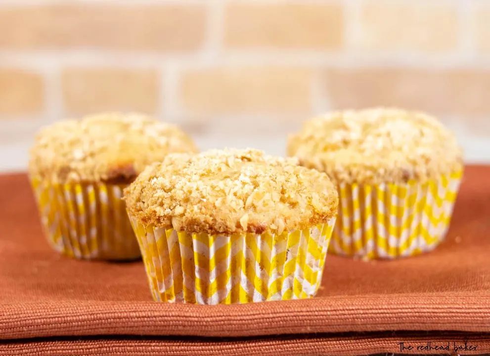 Three bakery-style peach crumb muffins
