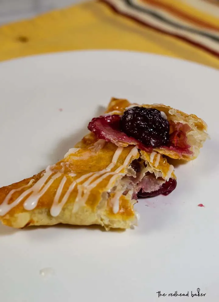 A cherry turnover broken in half with the filling exposed