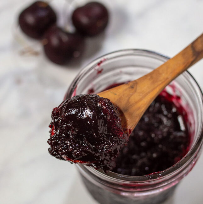 An overhead shot of a jar of cherry amaretto preserves