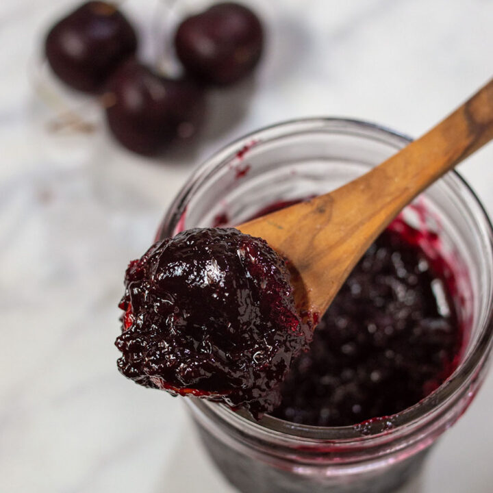 An overhead shot of a jar of cherry amaretto preserves