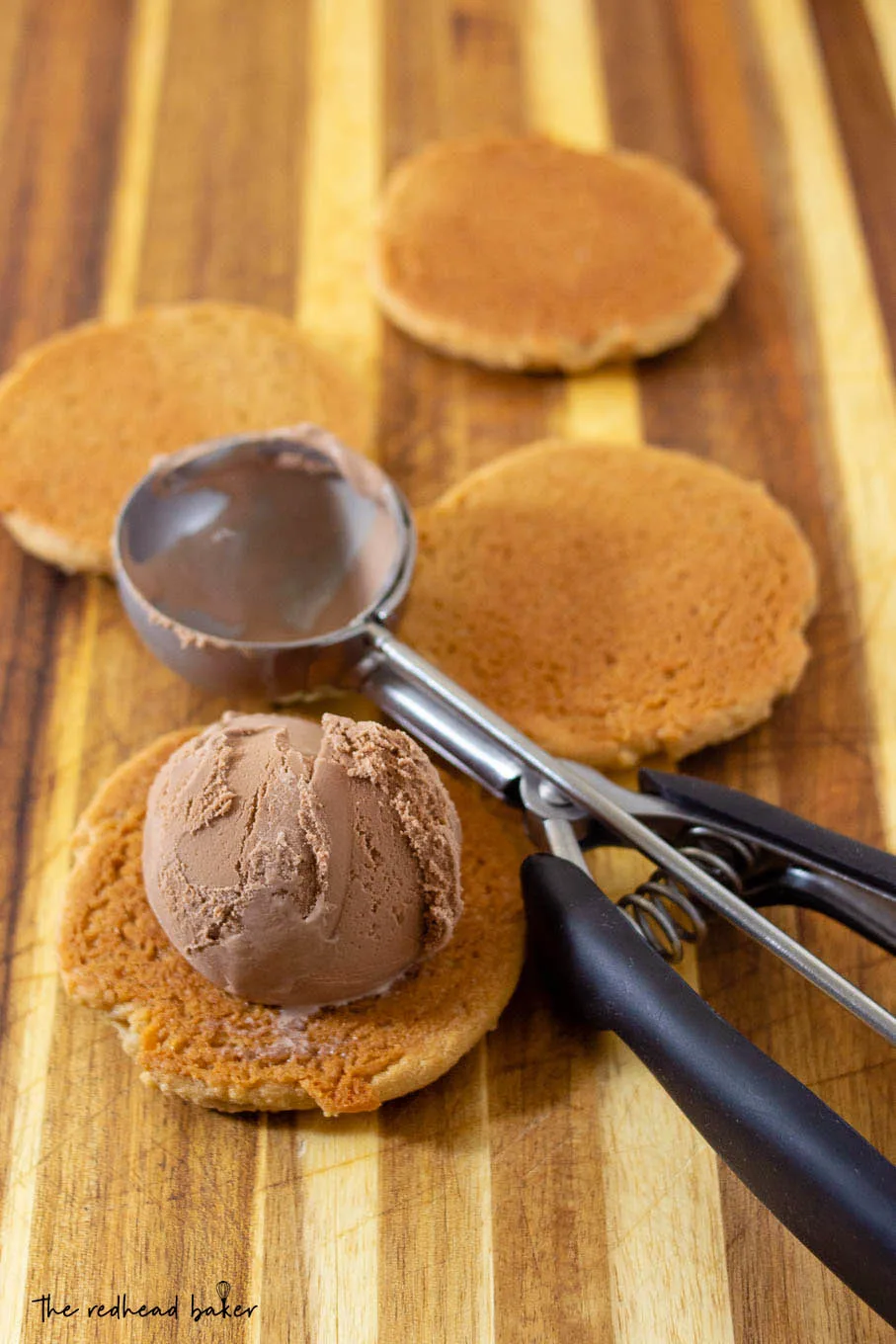 One peanut butter cookie topped with chocolate ice cream, and three plain cookies