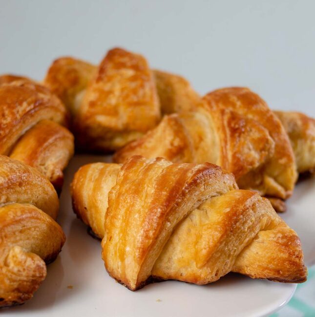 A close-up shot of a plate of mini butter croissants.